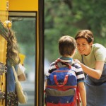 Mother sending son off to school at bus stop